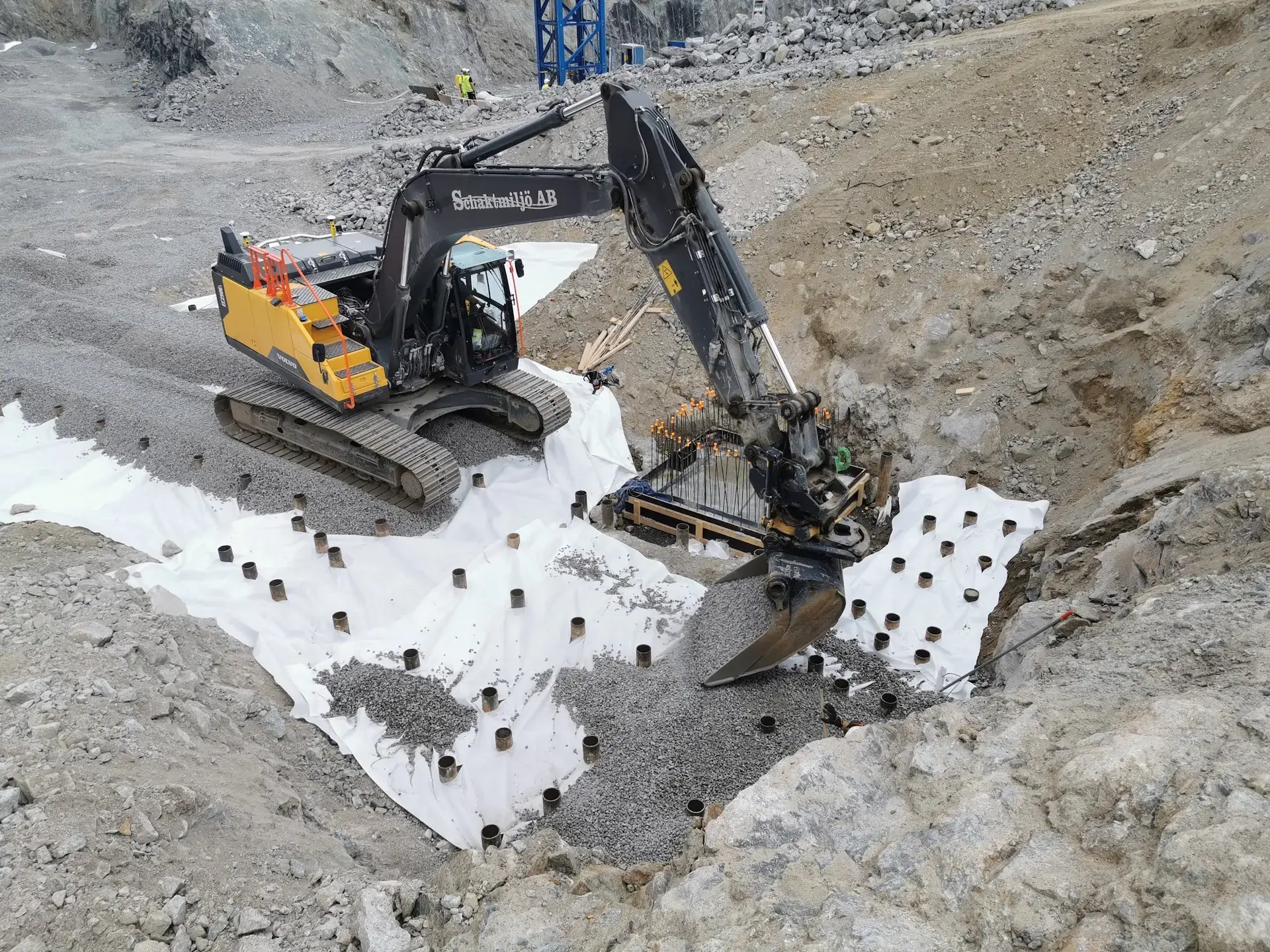 Schaktmiljös grävmaskin utför grundläggningsarbete i berg