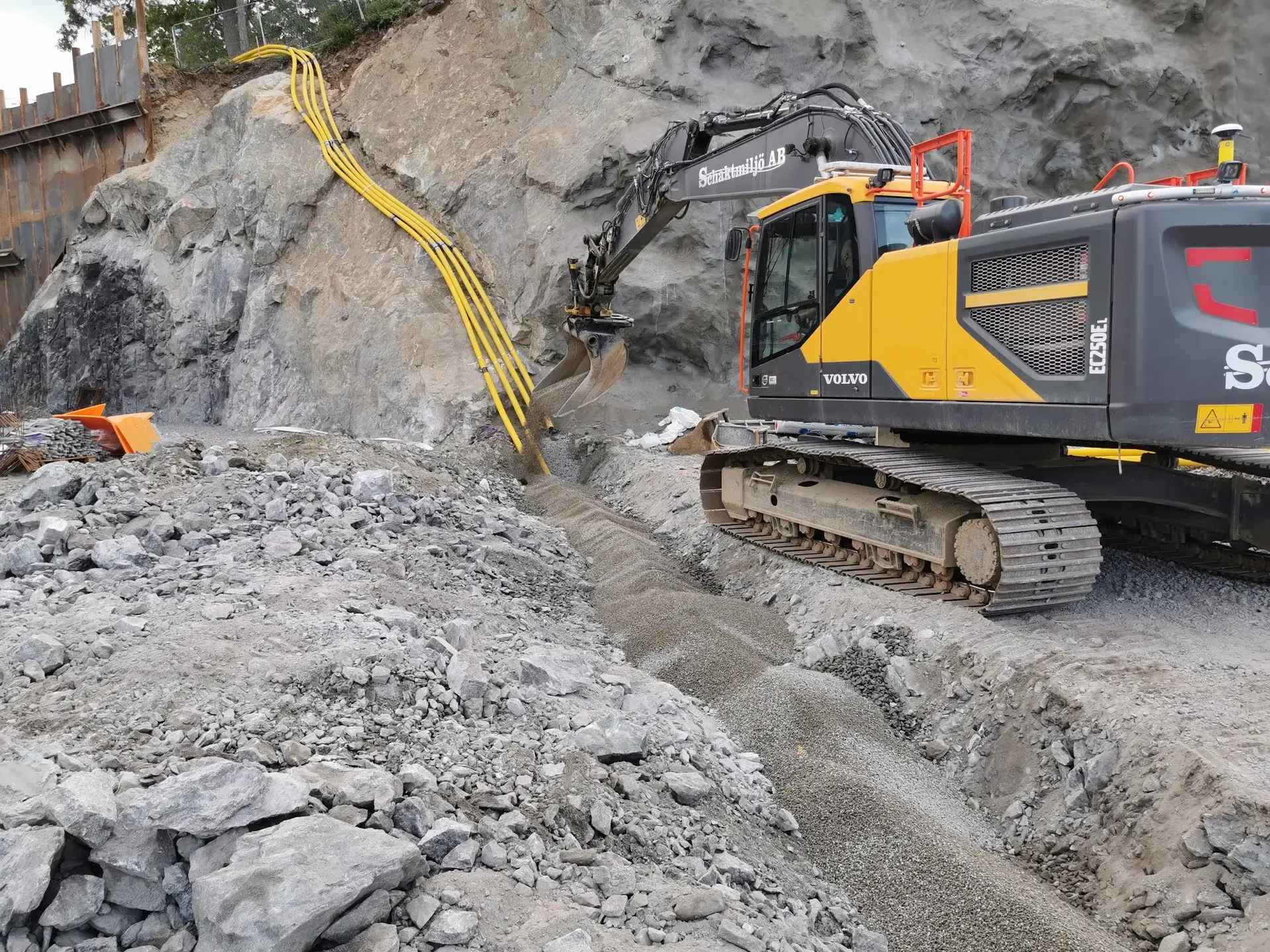 Schaktmiljös grävmaskin hanterar bergmaterial i ett större bergschakt