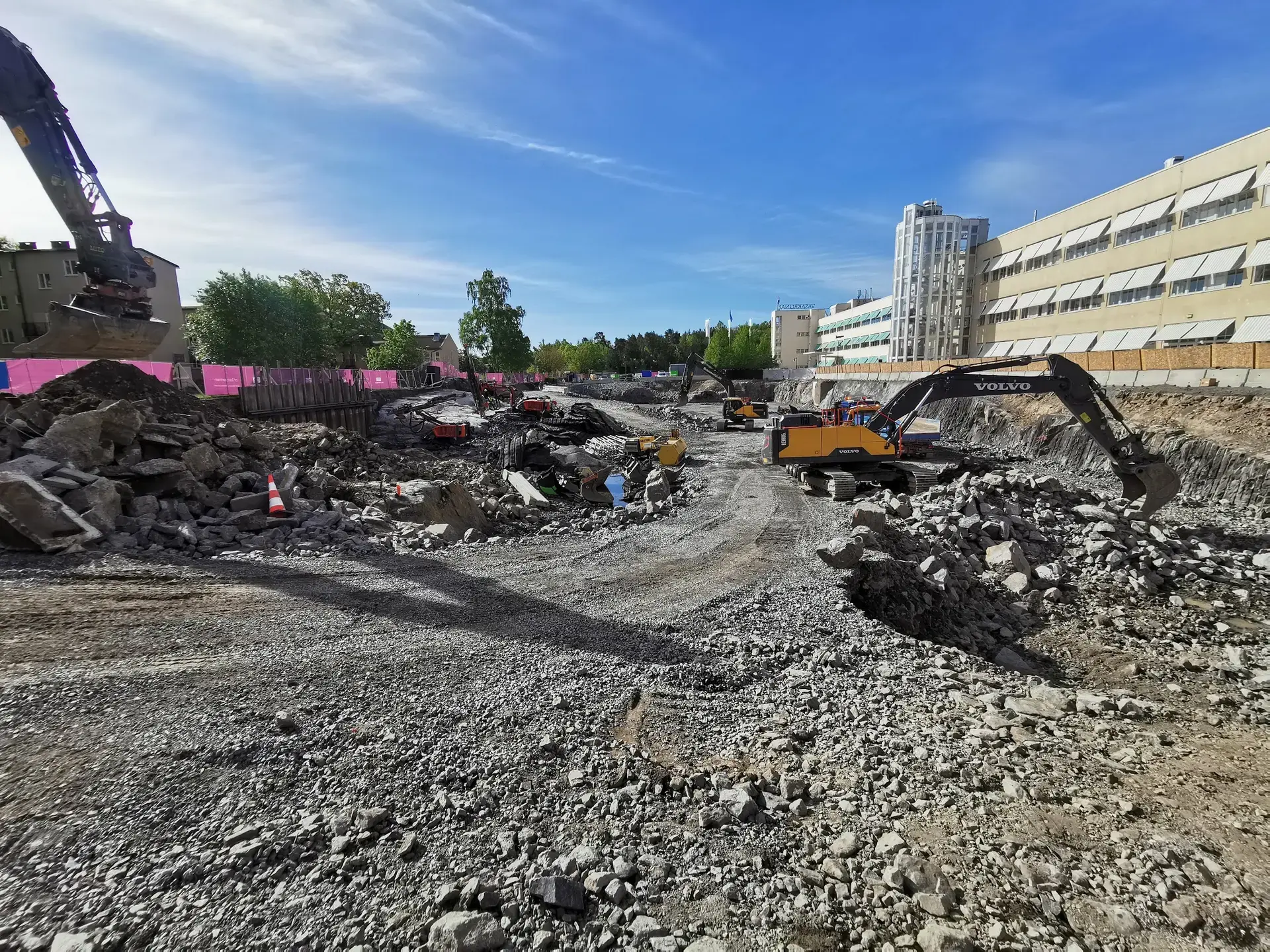 Maskiner hanterar jord- och bergmassor på ett arbetsområde